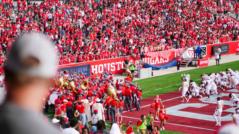 Cheerful fans at a college football game in Houston, TX, showcasing school spirit and vibrant energy.