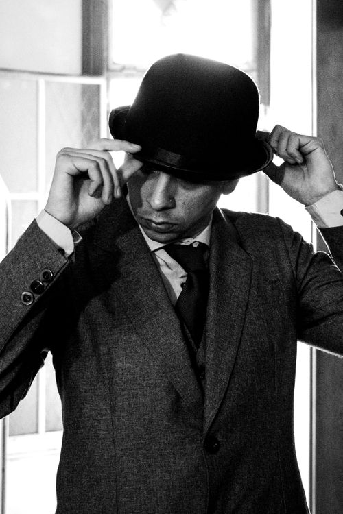 Free Black and white portrait of a man wearing a suit and fedora in an artistic pose. Stock Photo