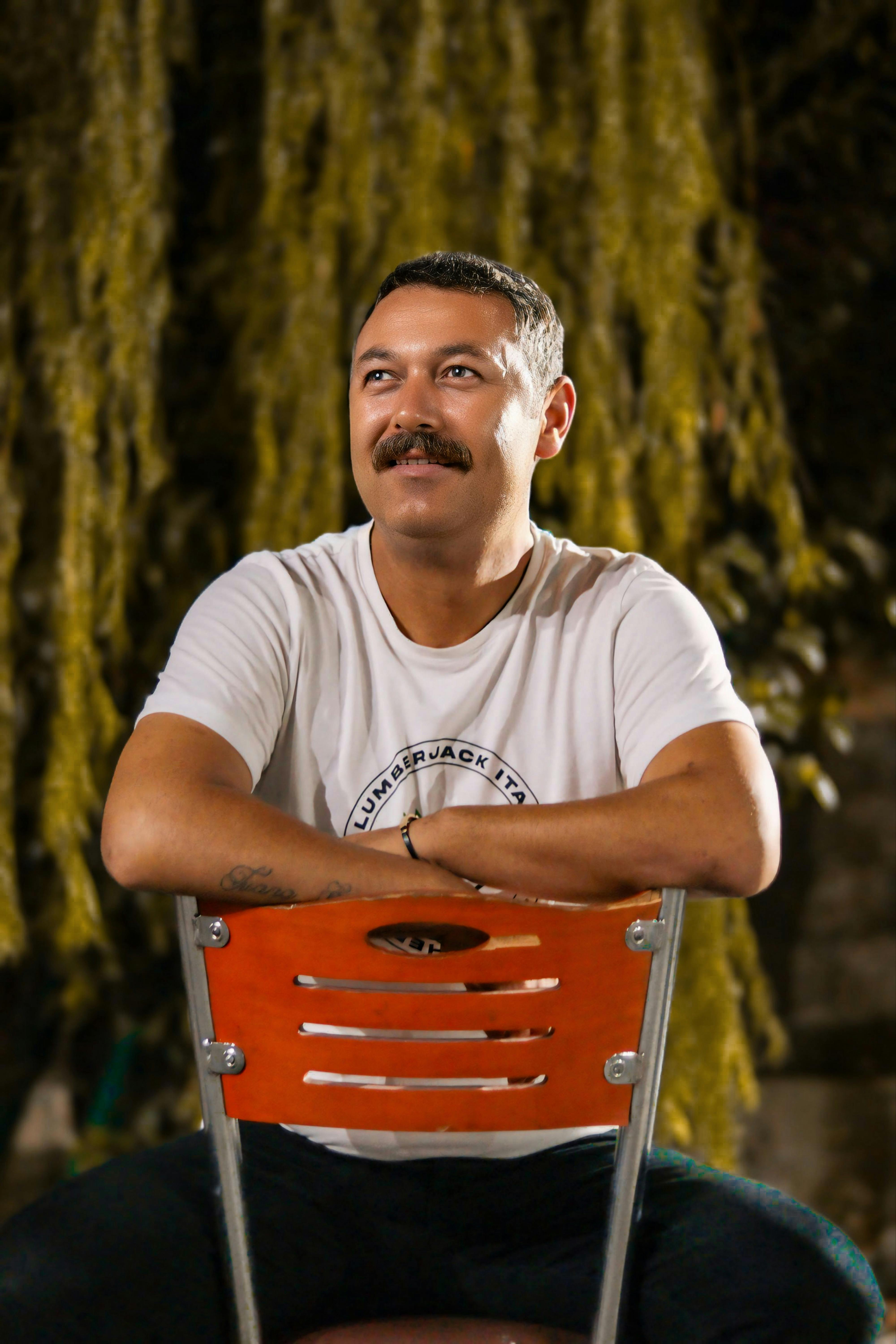 a man with a mustache sitting on a chair