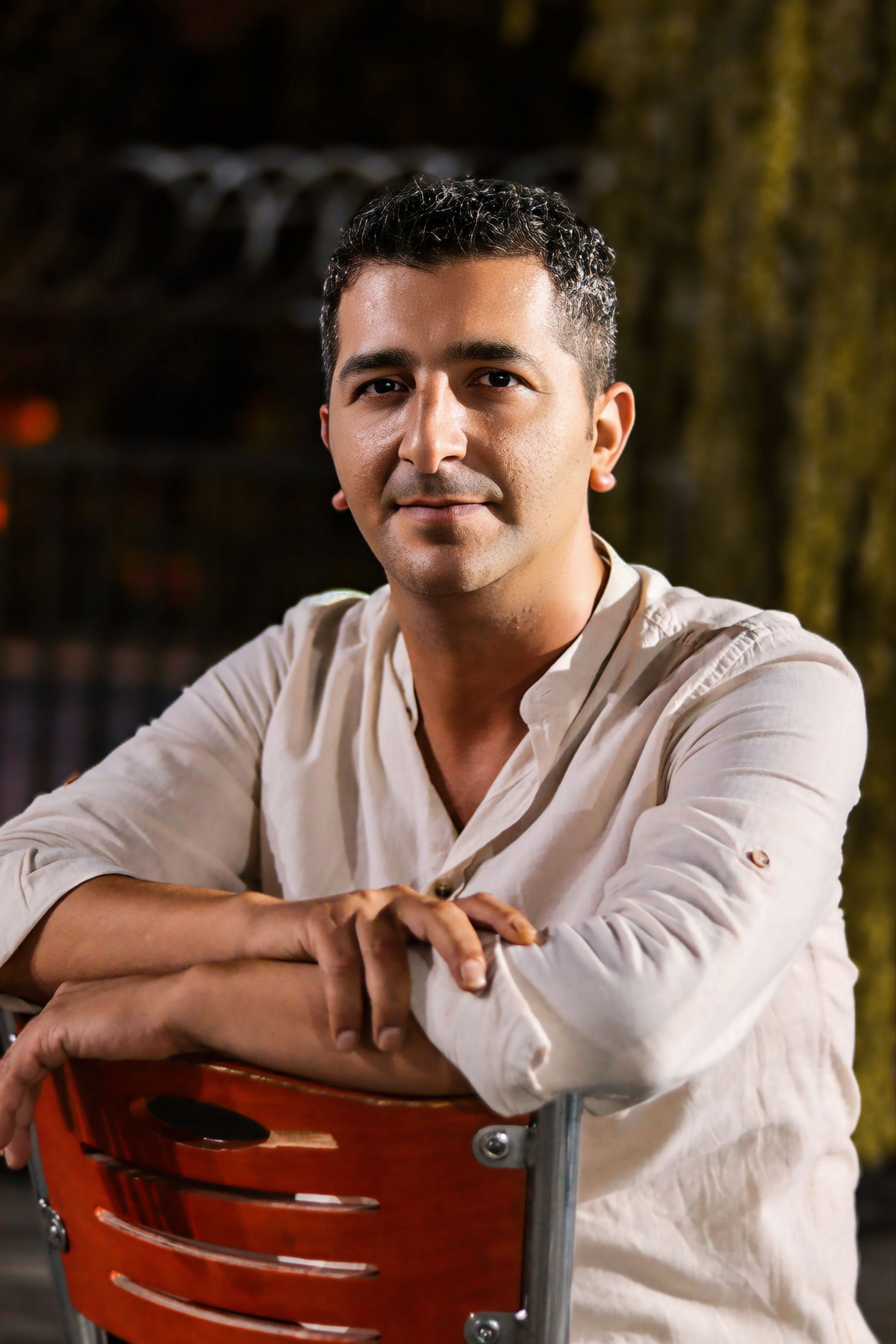 A man sitting on a chair outdoors, conveying relaxation and leisure.