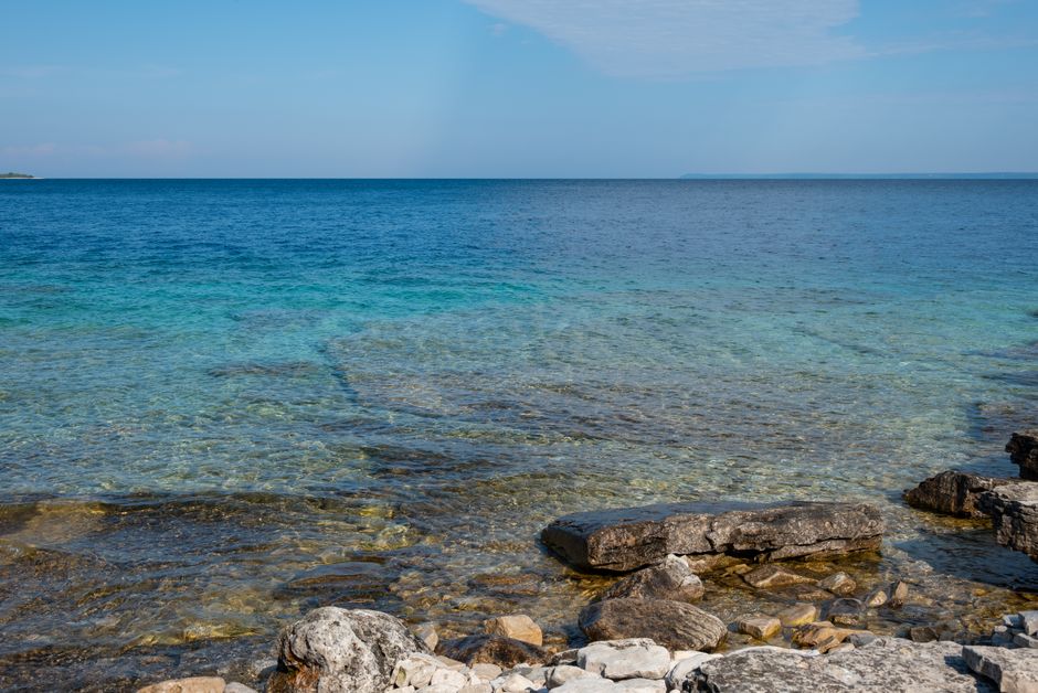 Tranquil view of the turquoise waters and rocky shoreline in Tobermory, Ontario.