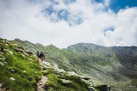 在罗马尼亚明亮的天空下，两名徒步旅行者探索着郁郁葱葱的青山，捕捉冒险的本质