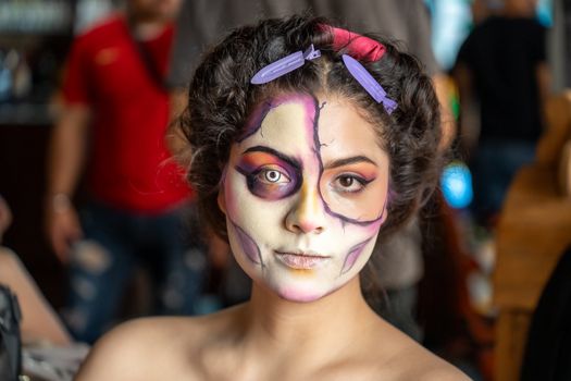 Close-up of a woman in Catrina makeup, showcasing Mexican culture and artistry in vivid colors.