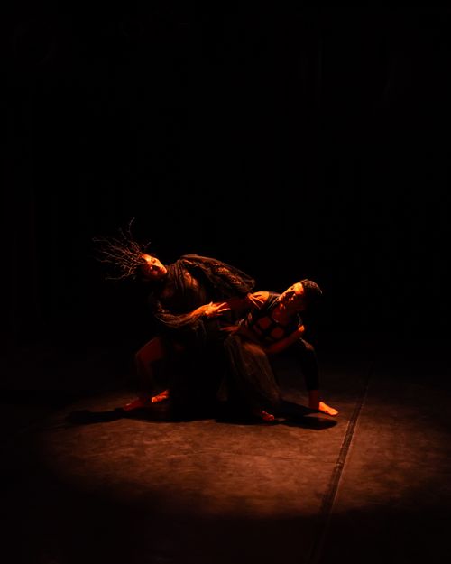 Free Two dancers perform an expressive routine in dramatic lighting, showcasing their artistic moves and synergy. Stock Photo