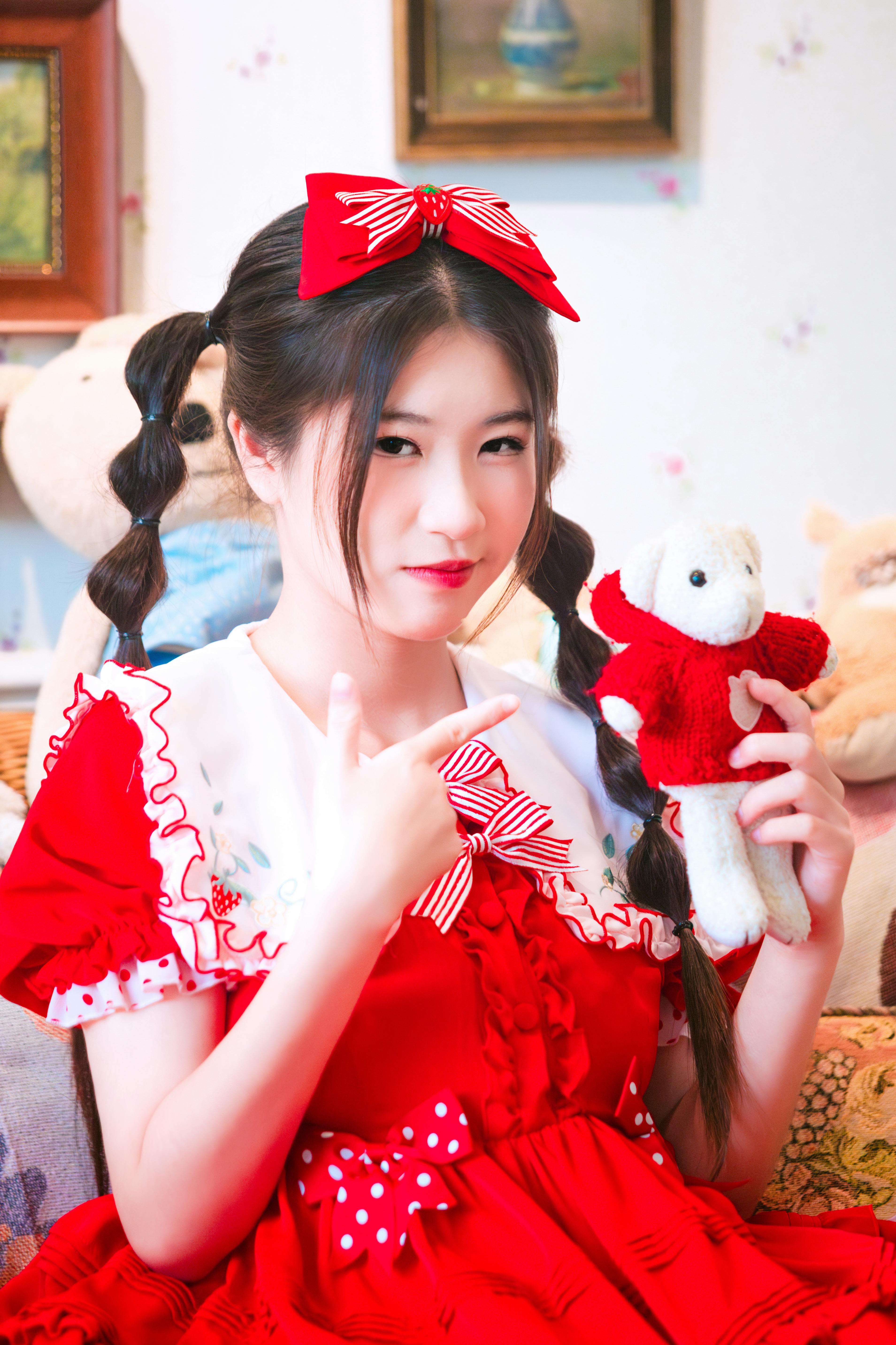 a woman in a red dress holding a teddy bear