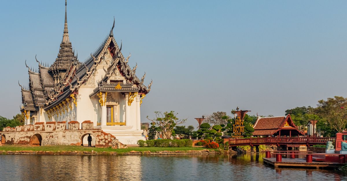 A Buddhist temple with intricate architecture reflected in a still lake