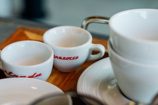 木托盘上堆放着白色咖啡杯和茶托