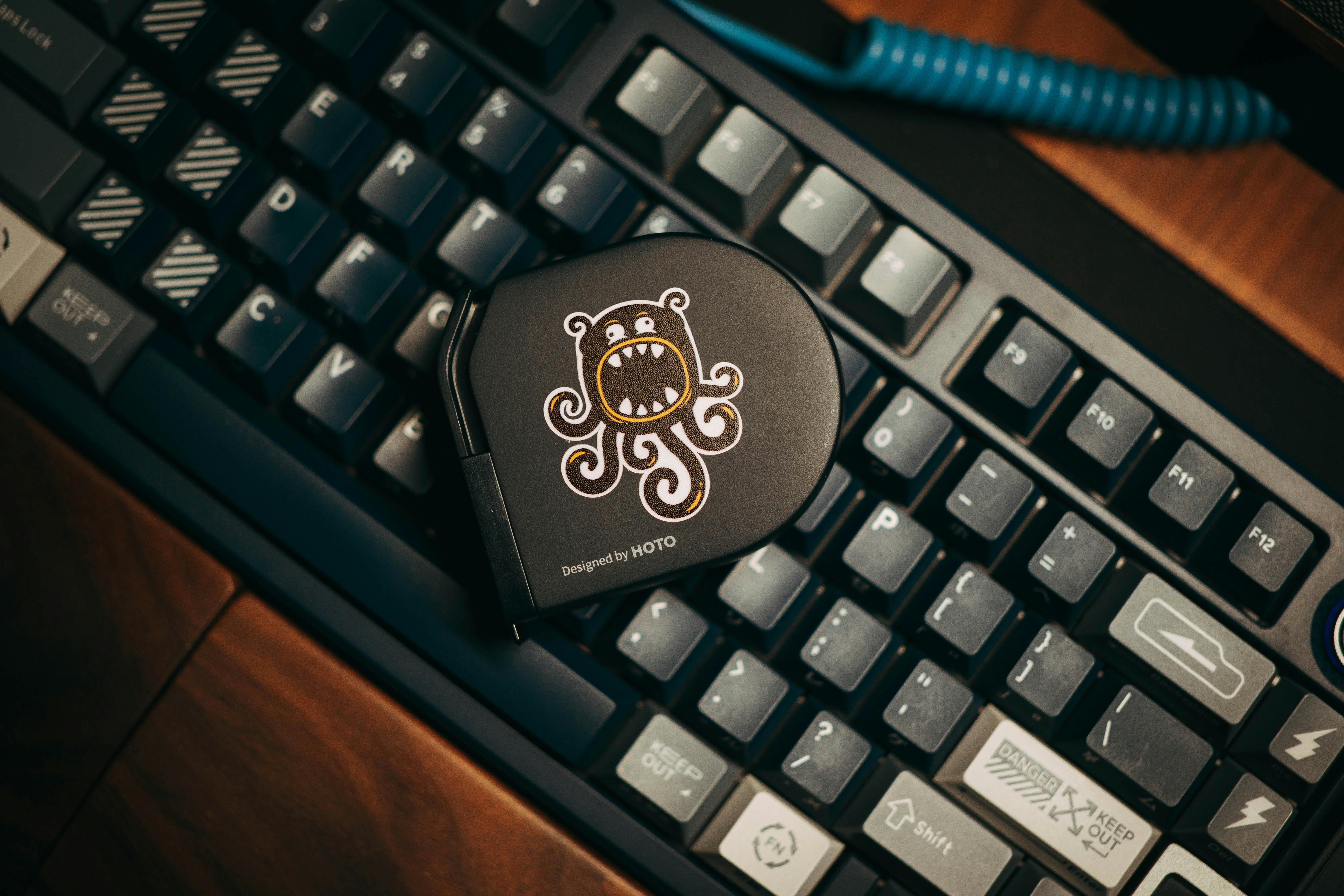 Close-up of a custom mechanical keyboard with a stylish gadget on top, showcasing modern design.