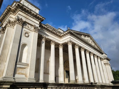 Free Stunning neoclassical architecture featuring grand columns and ornate details against a blue sky. Stock Photo