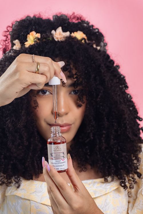Free Young woman applying skincare serum with a dropper, embracing beauty ritual. Stock Photo