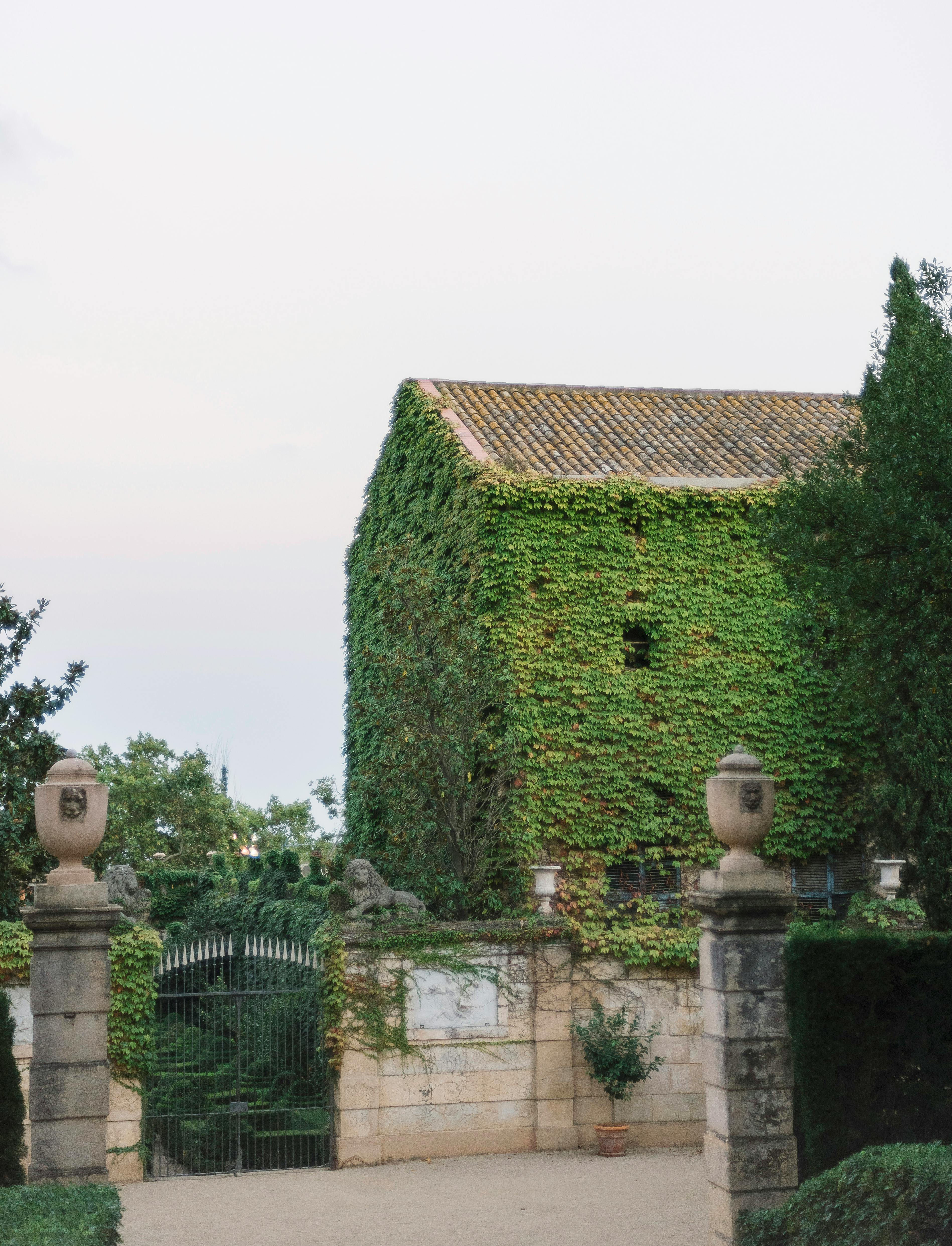 A serene ivy-covered stone building surrounded by lush gardens and ancient architecture.