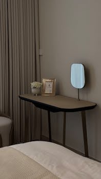 A sleek, modern bedroom with minimalist design in Dubai, featuring a stylish desk and mirror.