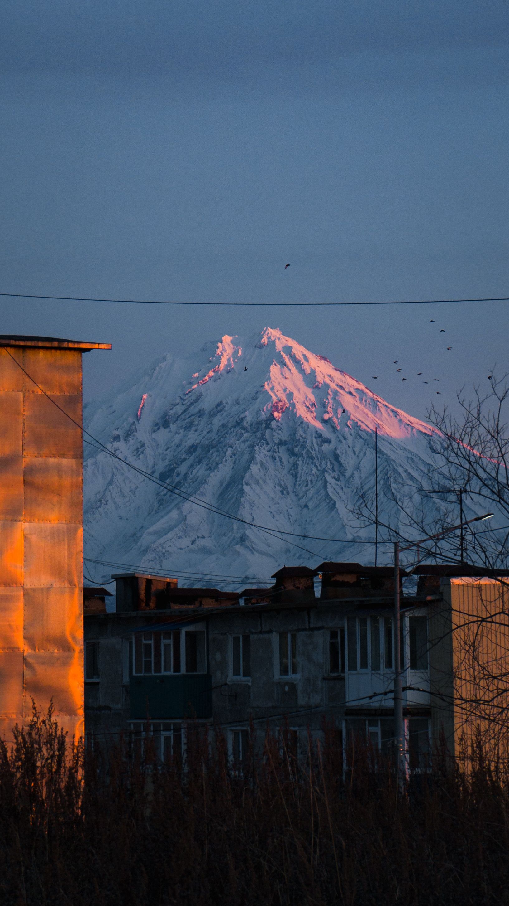A mountain is seen in the distance at sunset · Free Stock Photo