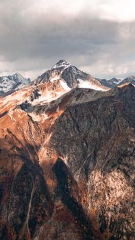 Breathtaking view of snow-covered mountain peak under dramatic sky, perfect for travel and nature lovers.