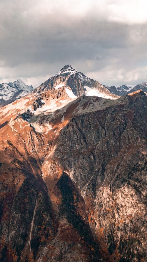 Free Breathtaking view of snow-covered mountain peak under dramatic sky, perfect for travel and nature lovers. Stock Photo