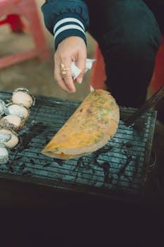 A street food vendor grills rice pancakes in Dalat, capturing the essence of Vietnamese cuisine.
