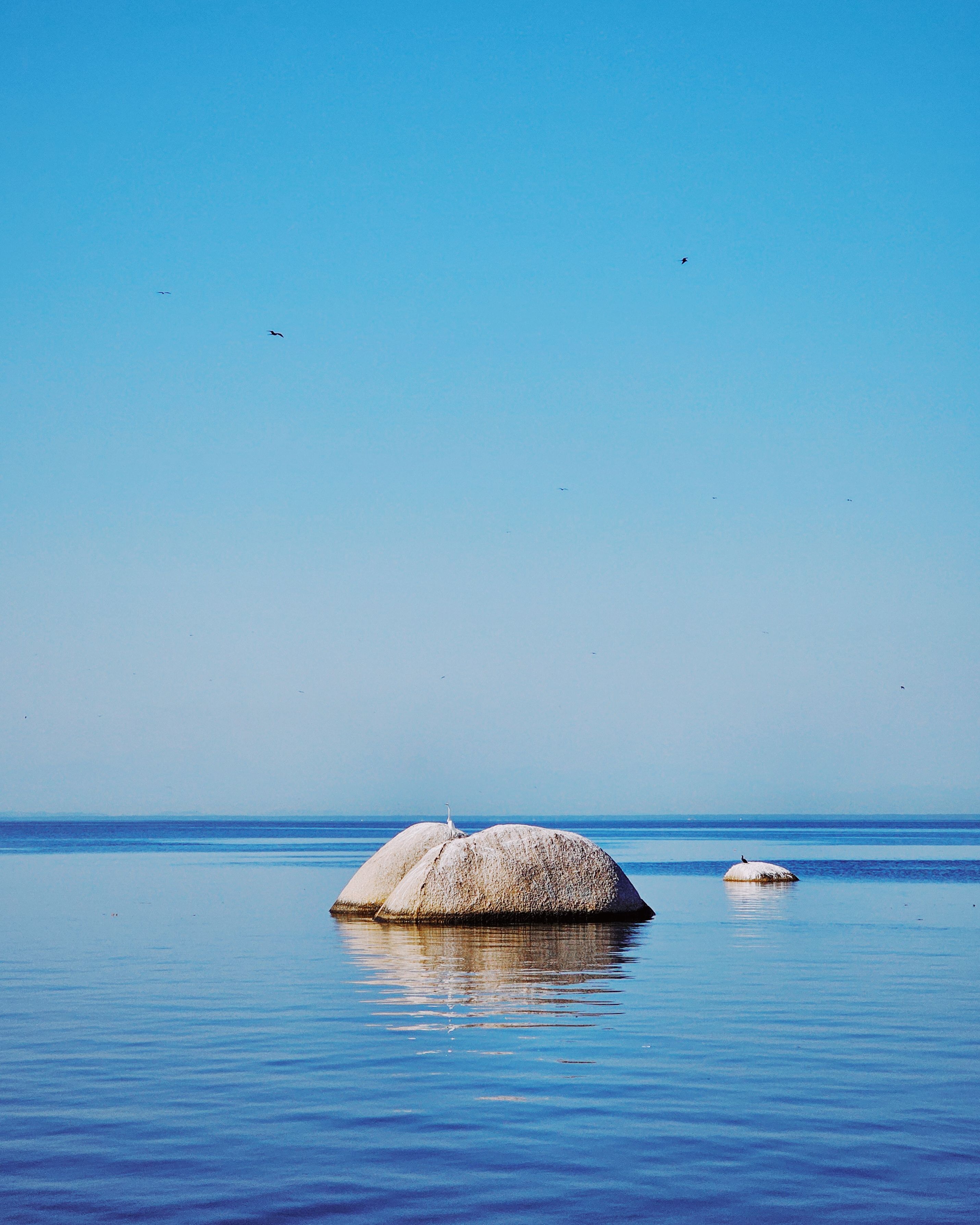 Two large rocks in the middle of a body of water · Free Stock Photo