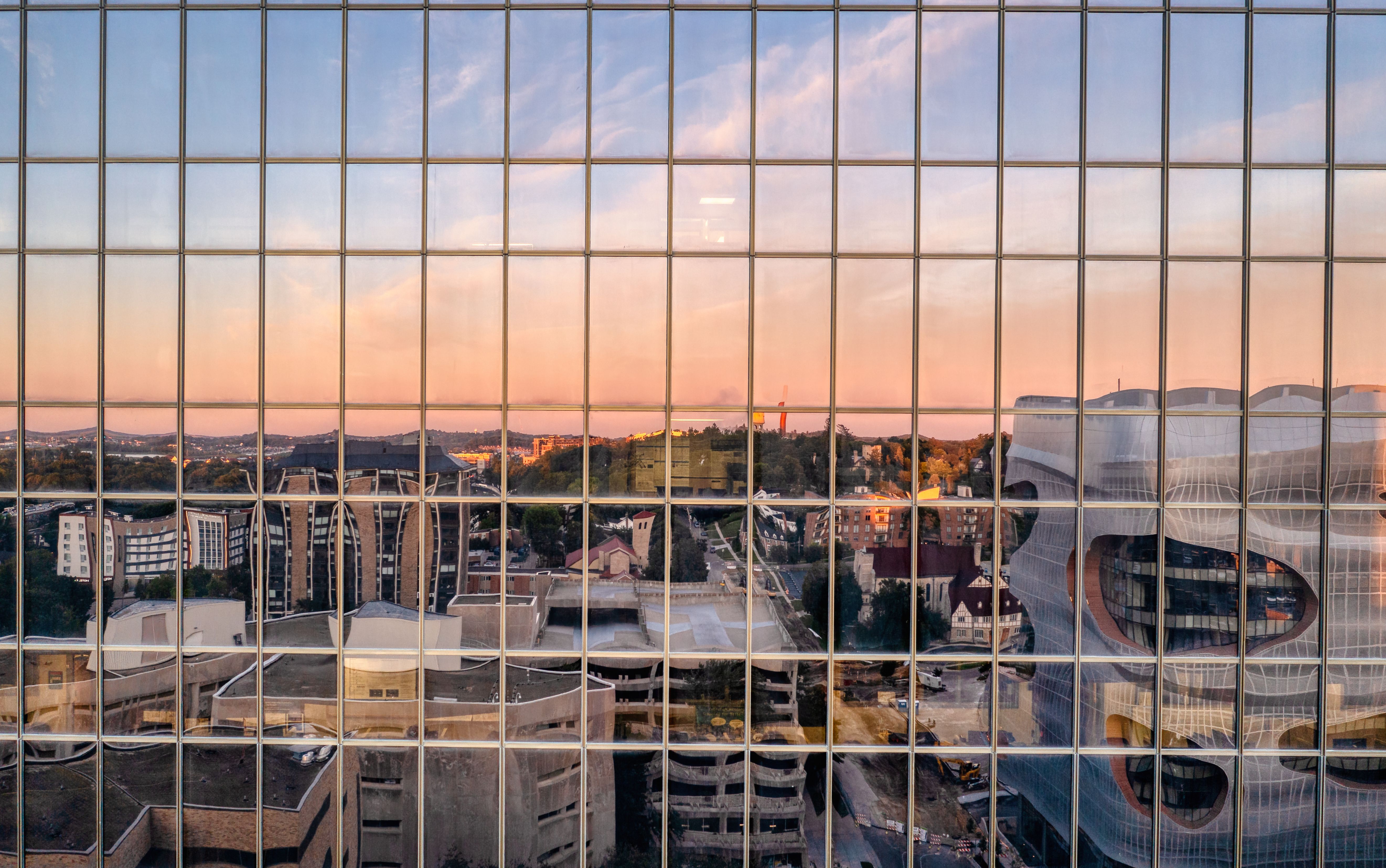 A city skyline is reflected in a glass window · Free Stock Photo