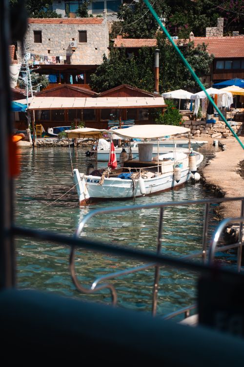 Free A picturesque view of a harbor in Demre, Antalya, Türkiye, showcasing fishing boats and waterfront houses. Stock Photo