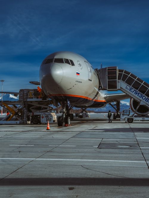Free Front view of a commercial airplane on the tarmac with boarding stairs at an airport. Stock Photo
