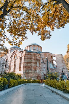 A stunning view of a Byzantine church surrounded by autumn foliage, showcasing historic architecture.