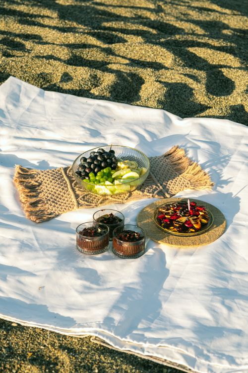 Free A summer beach picnic with fruits and snacks on a sandy shore. Stock Photo