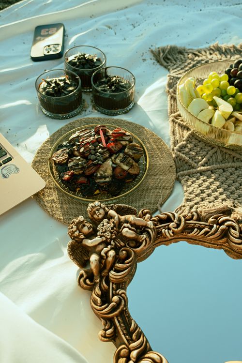 Free Luxurious picnic with dried fruits, fresh grapes, ornate mirror, and desserts on white cloth. Stock Photo