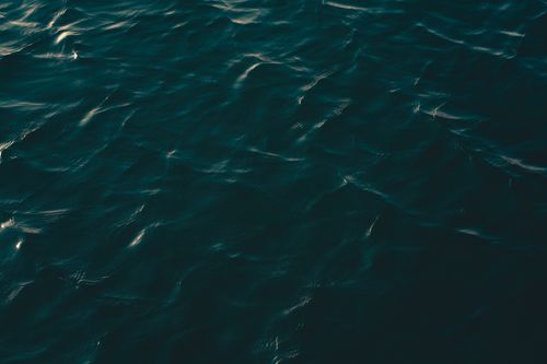 Free Serene ocean surface with gentle ripples during sunset creating a tranquil pattern. Stock Photo