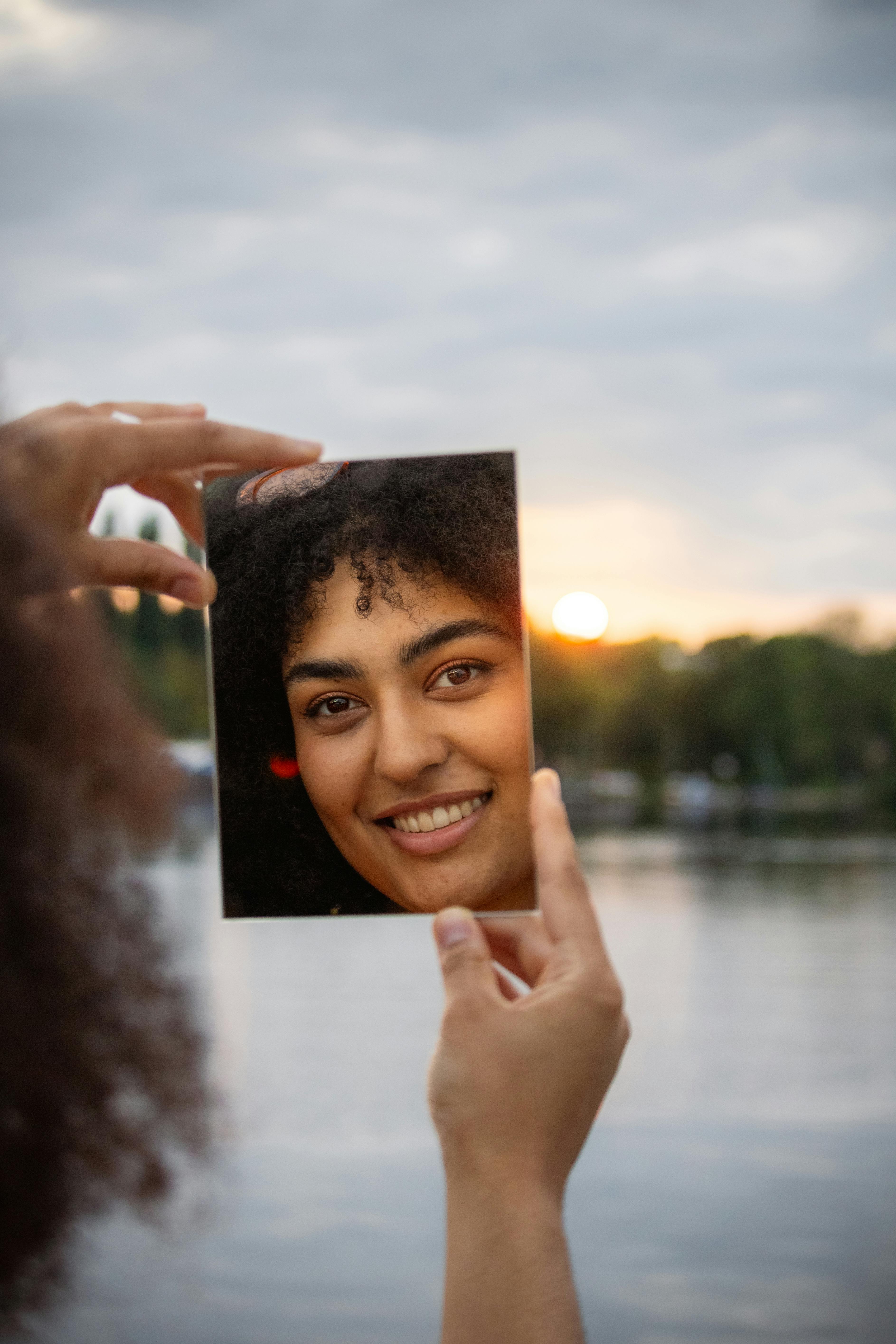 a woman holding up a photo of herself