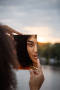 A captivating portrait of a woman reflected in a mirror during sunset in Hamburg.