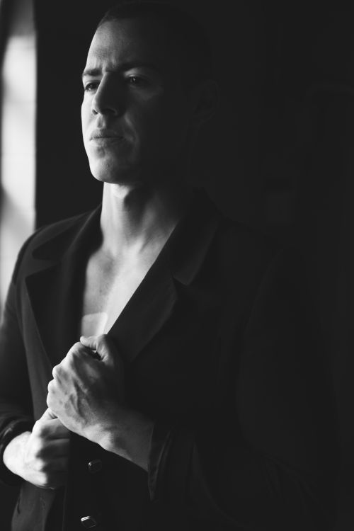 Free Striking black and white portrait of a pensive man in a stylish outfit posing indoors. Stock Photo
