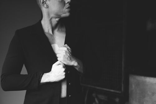 Free Moody black and white portrait of a man adjusting his suit, exuding style and elegance. Stock Photo