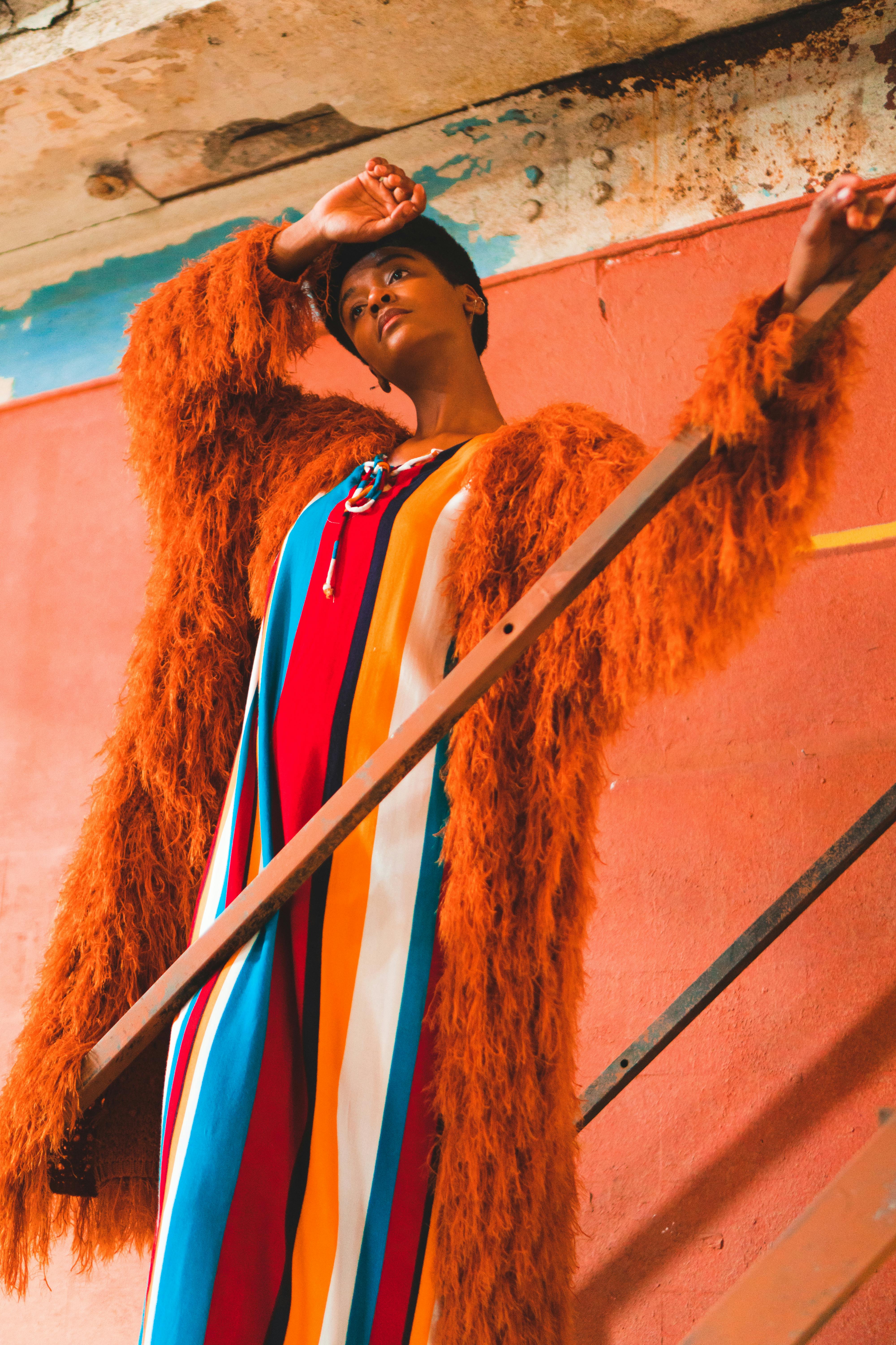 这张充满活力的时尚肖像照，描绘了一位身穿彩色毛皮大衣的模特在户外摆姿势的情景