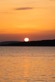 Serene sunset over the sea with a warm yellow sky in Bursa, Turkey.