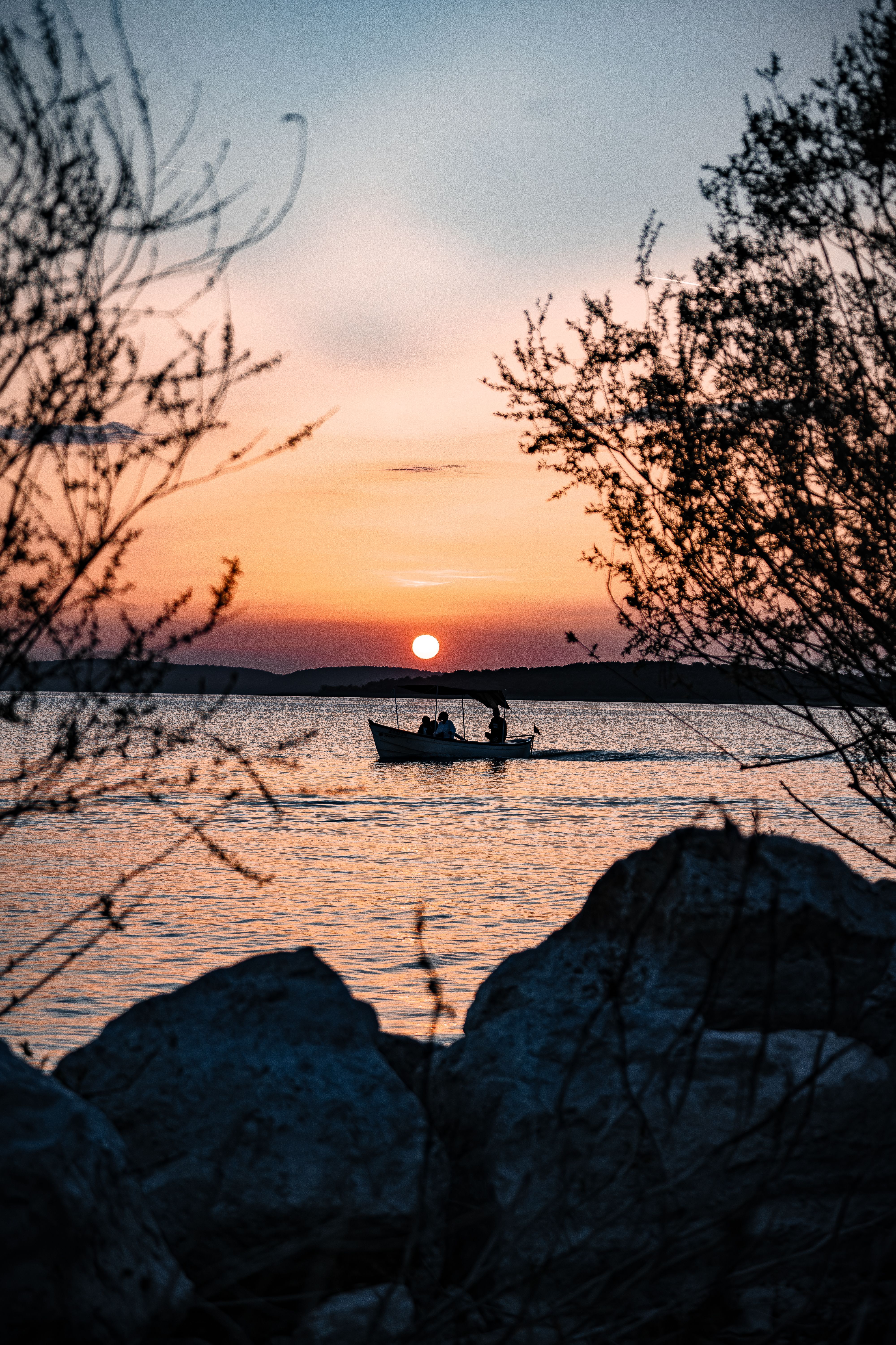 Silhouette of People on Boat on Lake in Evening · Free Stock Photo