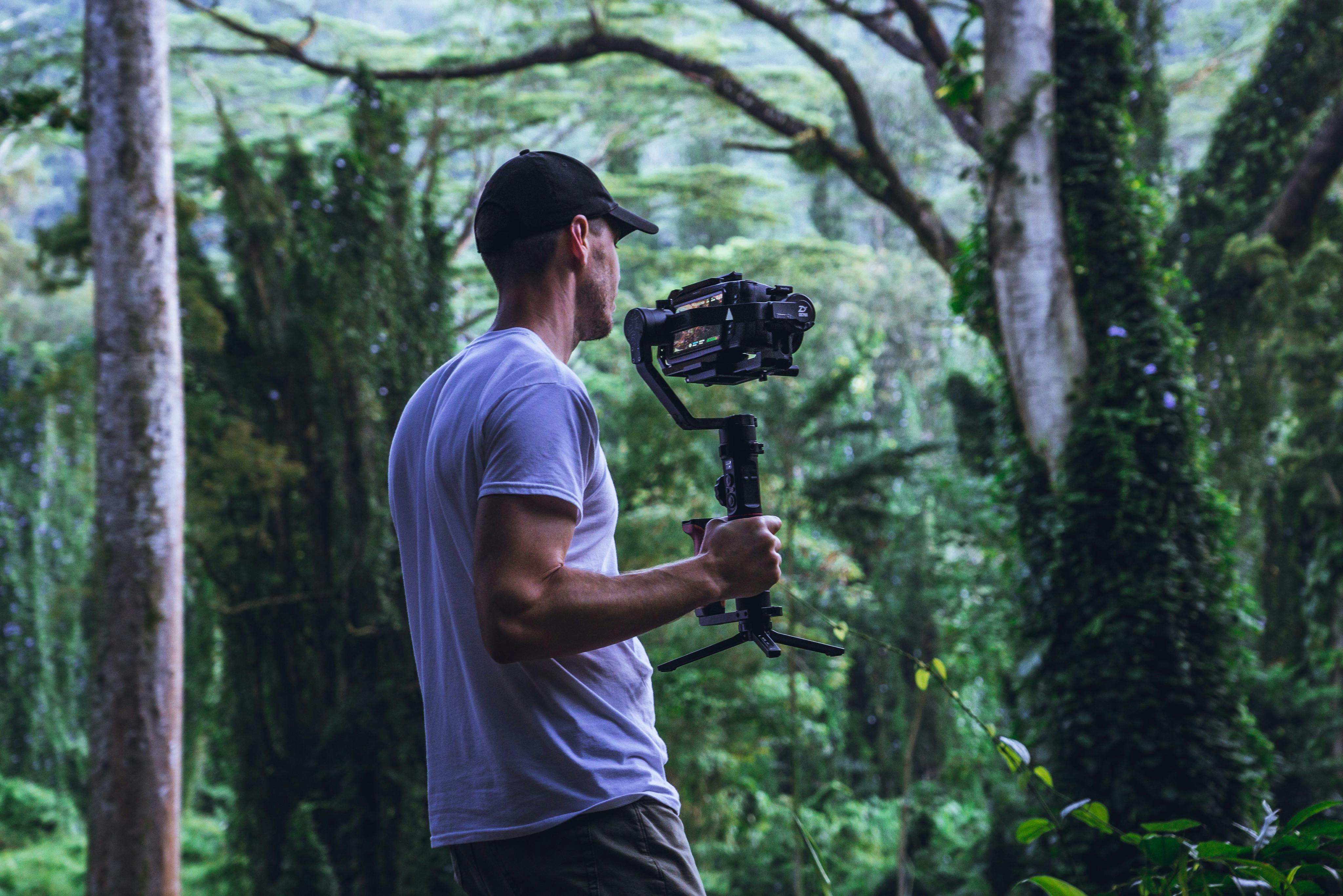 man in white shirt holding camera