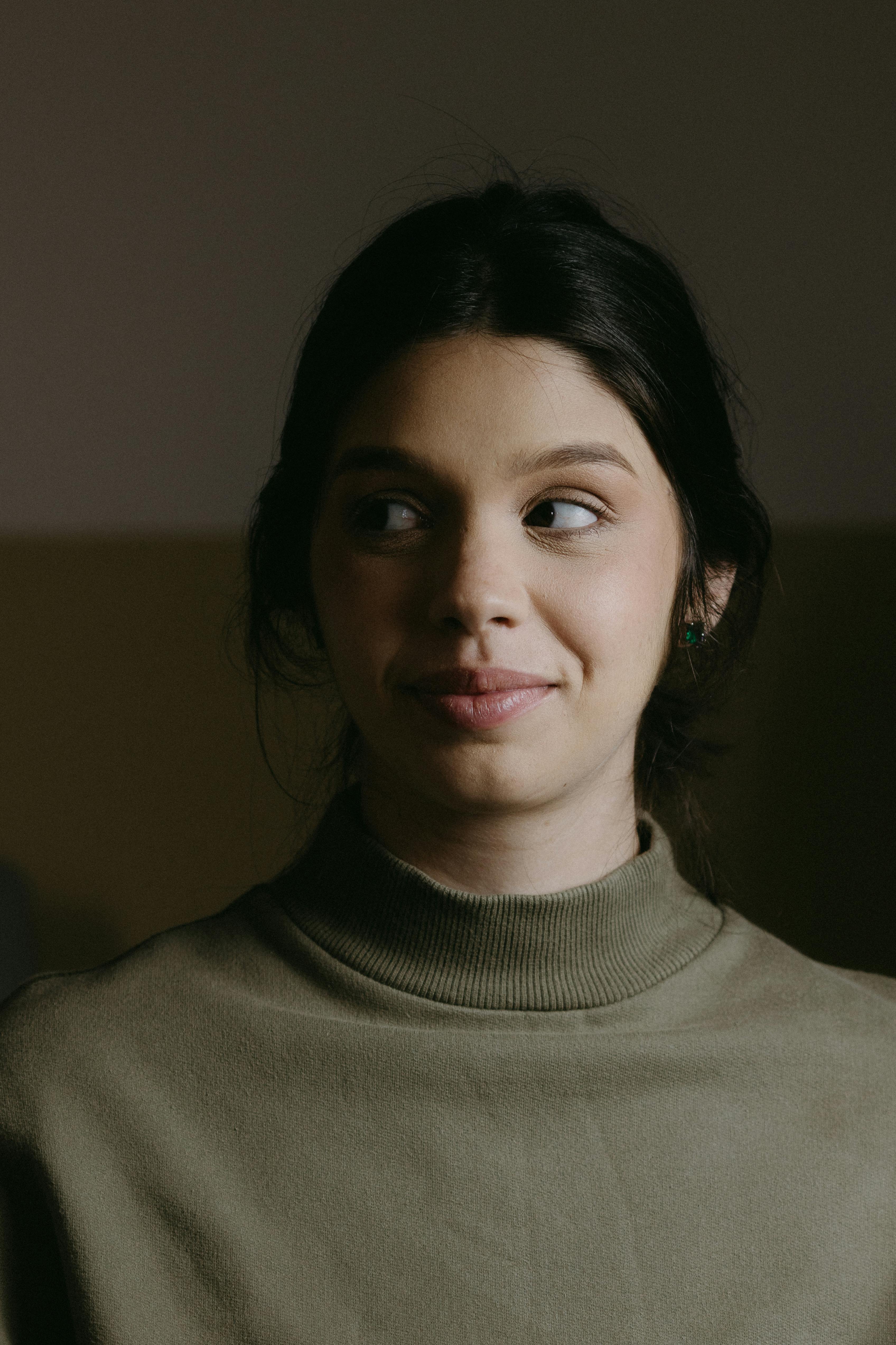 a woman in a green turtle neck sweater