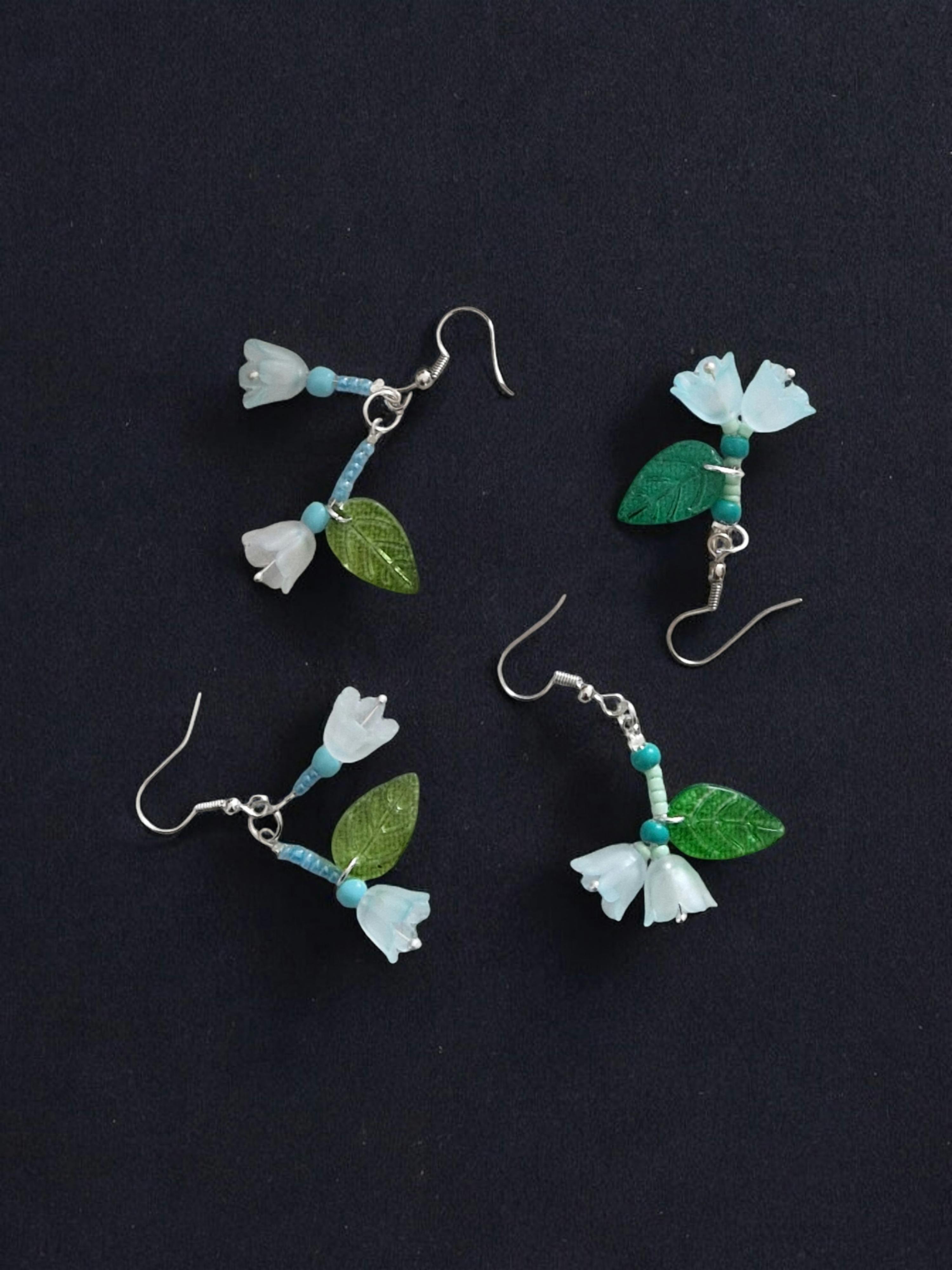 three pairs of earrings with flowers and leaves