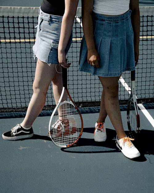 Two Women Holding Tennis Rackets