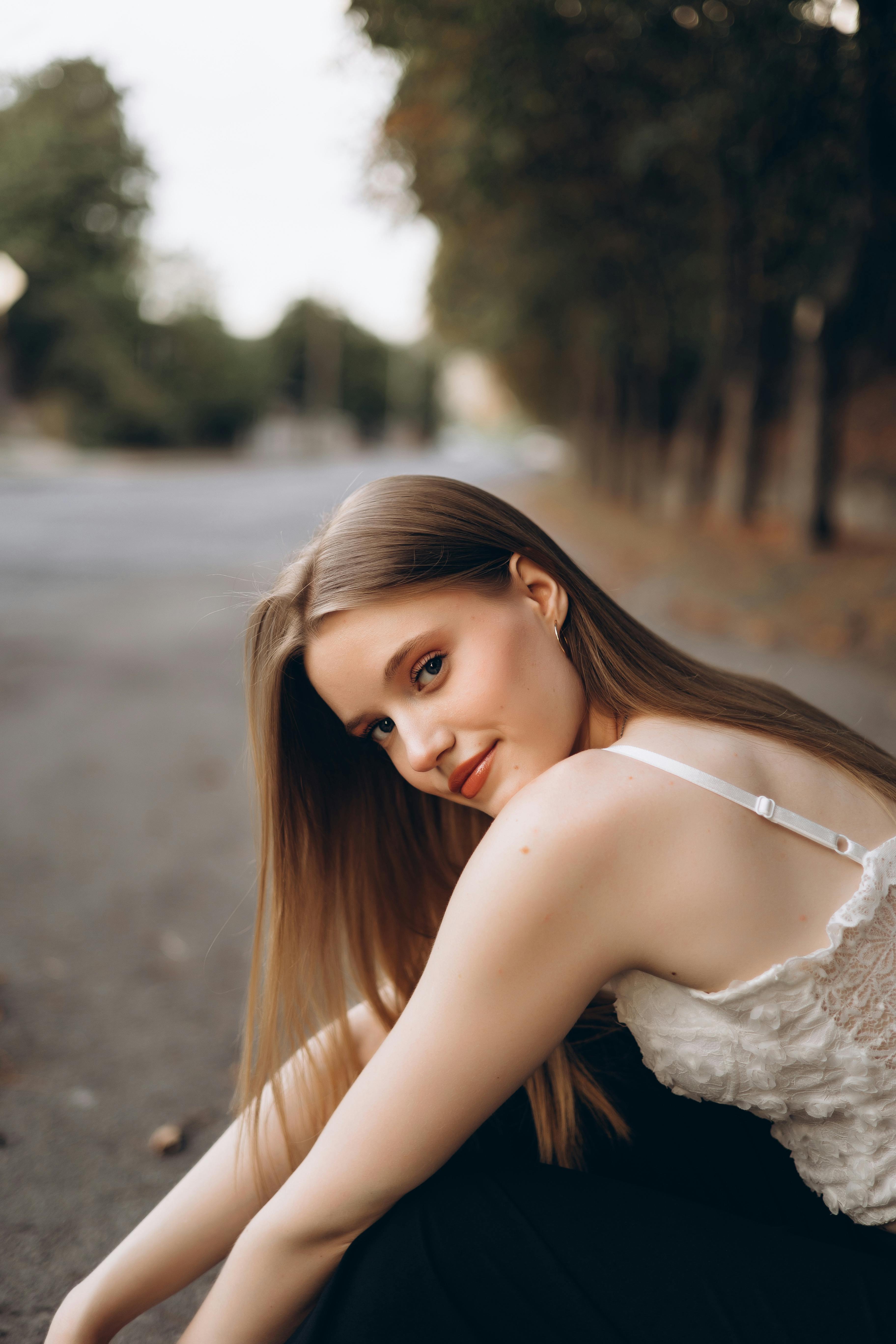 a beautiful young woman sitting on the ground