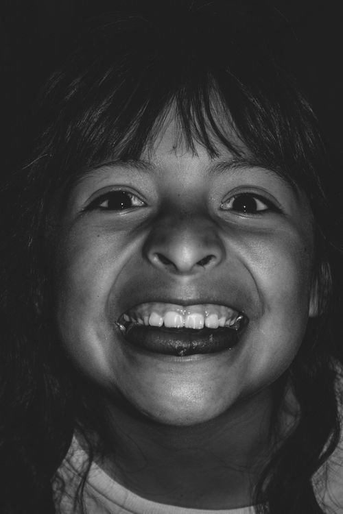 Free Black and white portrait of a smiling Hispanic child showcasing joy and innocence. Stock Photo