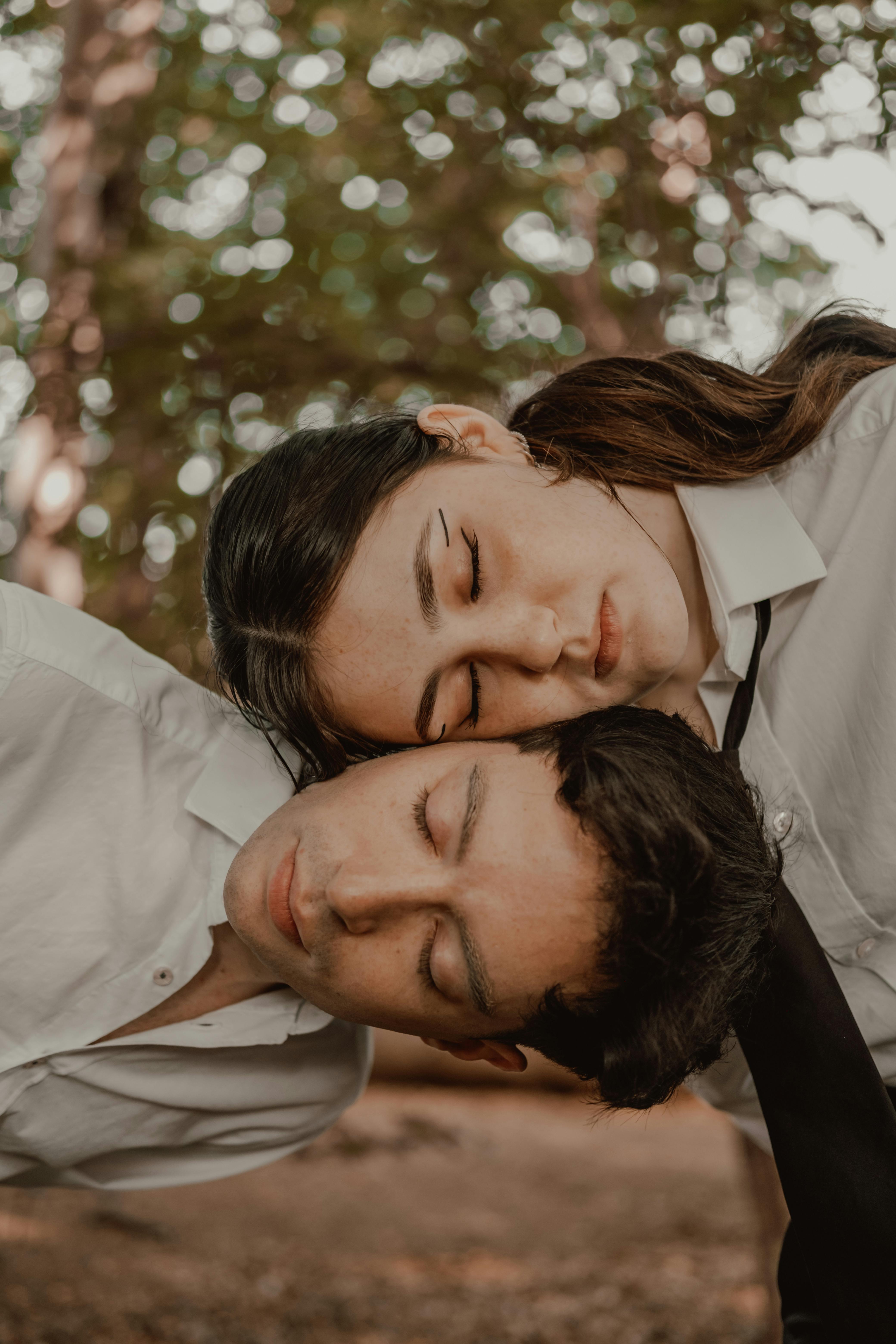 a couple in white shirts and ties are laying on the ground