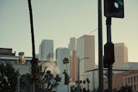 黄昏时分，城市天际线上高耸的摩天大楼引人注目，棕榈树和红绿灯也清晰可见