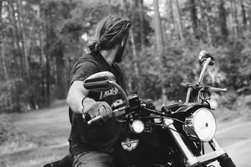 Man Riding a Black Motorcycle In Gray-scale Photography