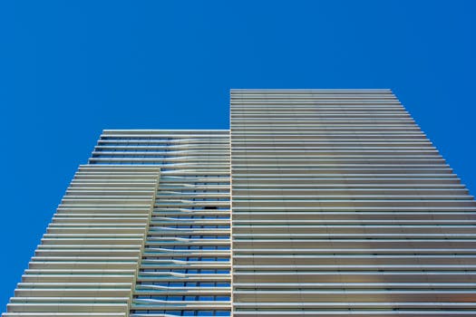 Striking view of a contemporary skyscraper facade in Den Haag, featuring glass and steel architecture.