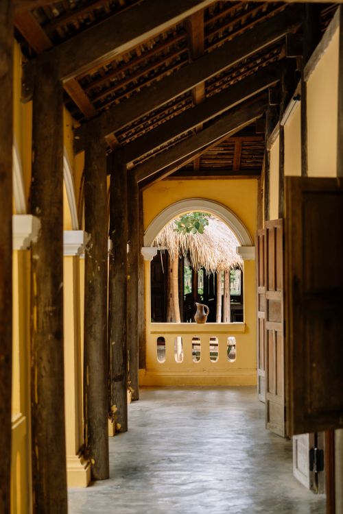 Free A rustic hallway featuring wooden beams, arches, and natural light filtering through. Stock Photo