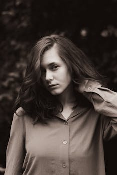 Elegant sepia portrait of a woman with flowing dark hair in a classic pose.