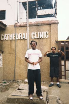 Two men pose in front of Cathedral Clinic for a street style photo.