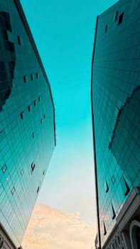 Elegant view of modern skyscrapers with reflective glass facades against a blue sky, capturing urban elegance.