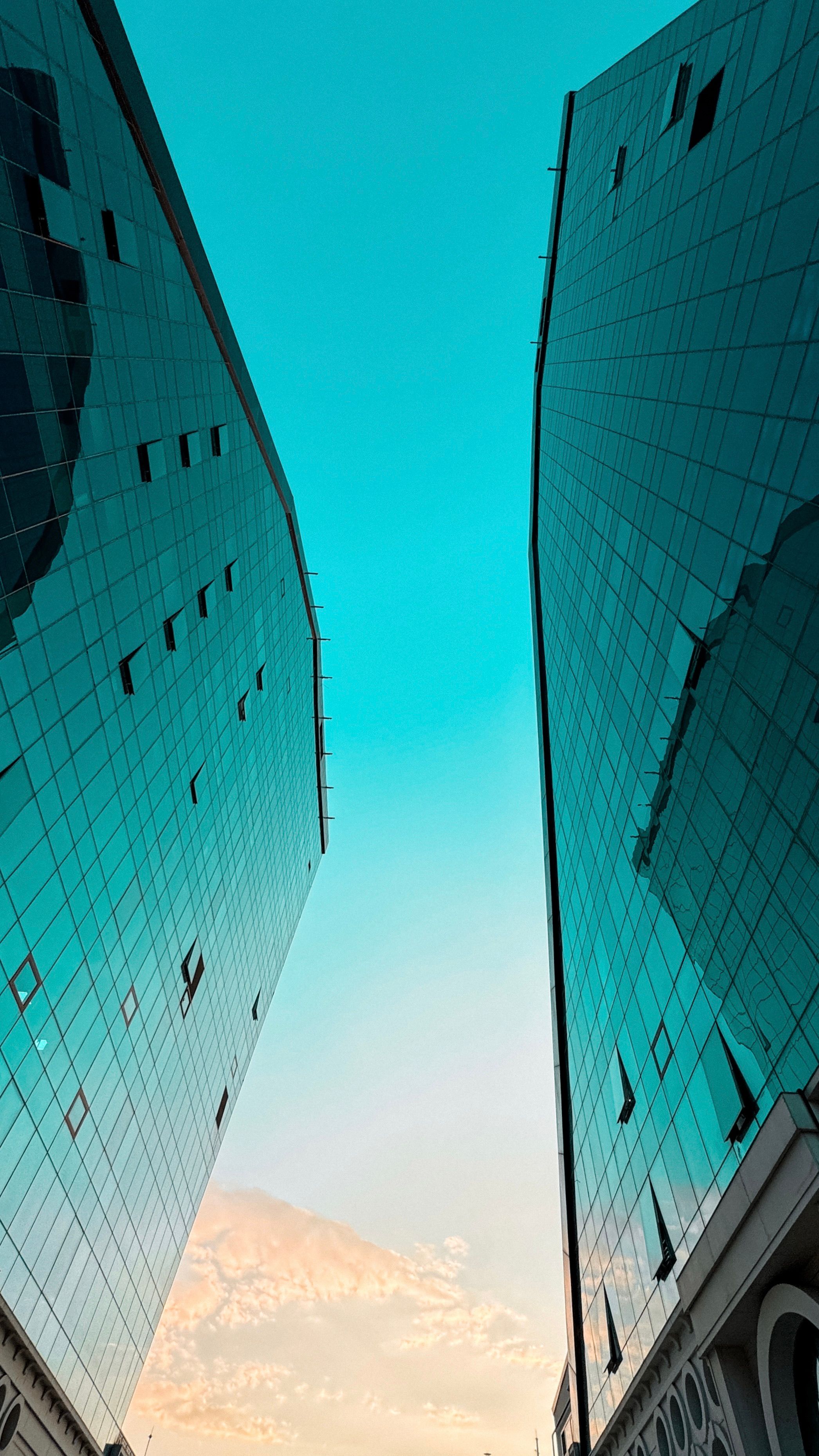 Two tall buildings with a blue sky in the background · Free Stock Photo